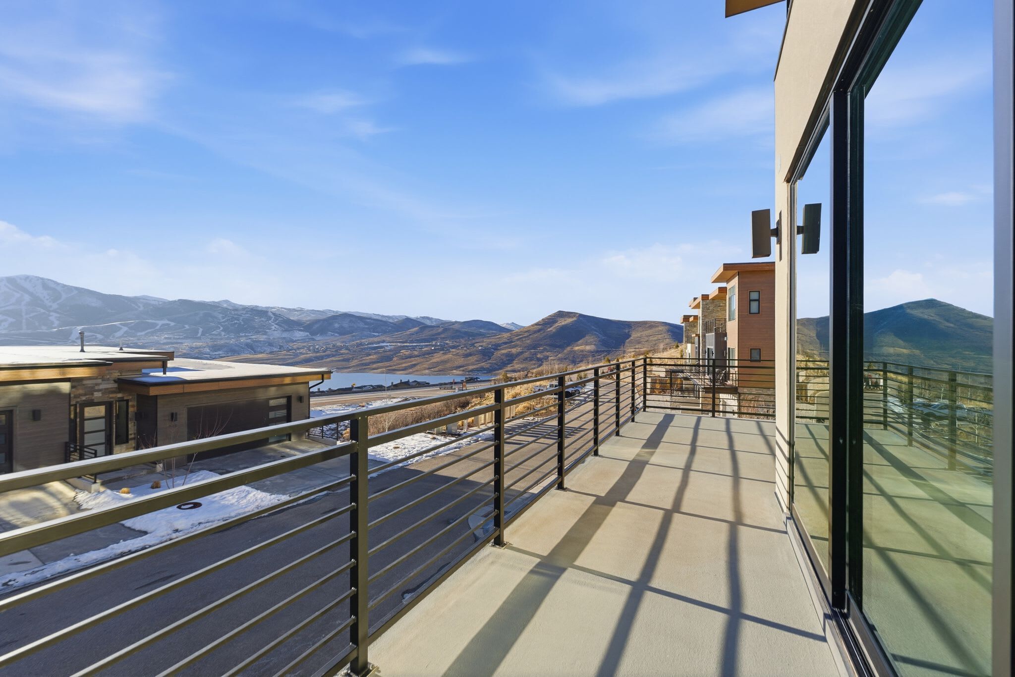 Un balcon avec vue sur les montagnes et un lac.