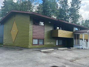 Un bâtiment à deux étages doté d’un balcon, d’un garage et d’une allée.