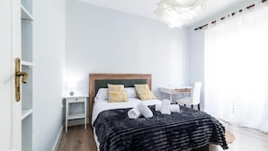 Ein modernes Schlafzimmer mit Bett, Nachttischen, Schreibtisch und Stuhl.