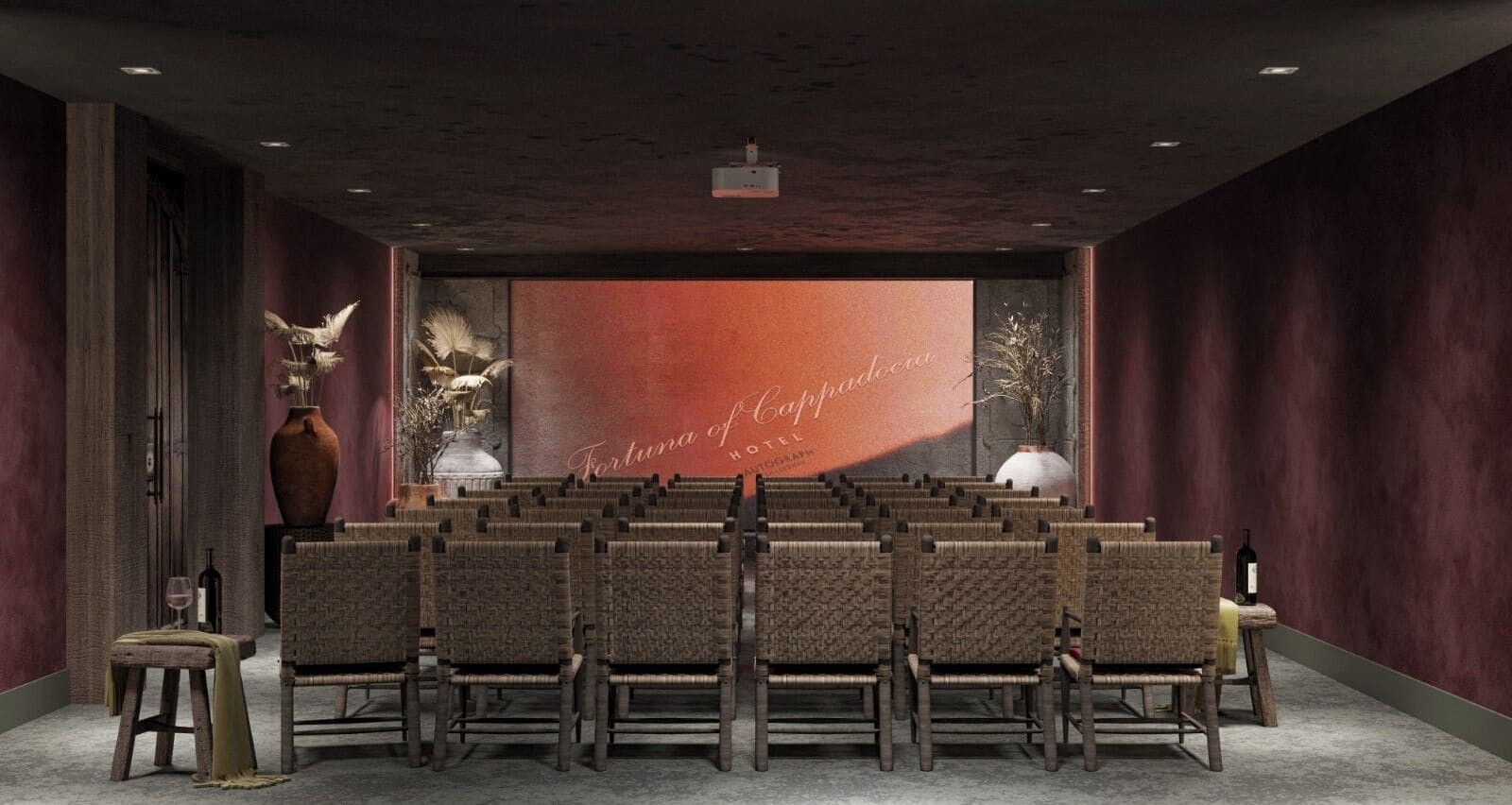 A conference room with rows of chairs, a large screen with text, and decorative vases.