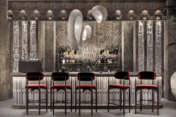 A bar area with a stone wall, bar stools, and a variety of bottles. - Fortuna Of Cappadocia, Autograph Collection (Nevşehir)