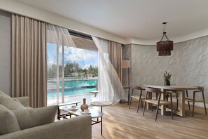 Una camera d'albergo moderna con un'ampia finestra, un'area relax e vista piscina.