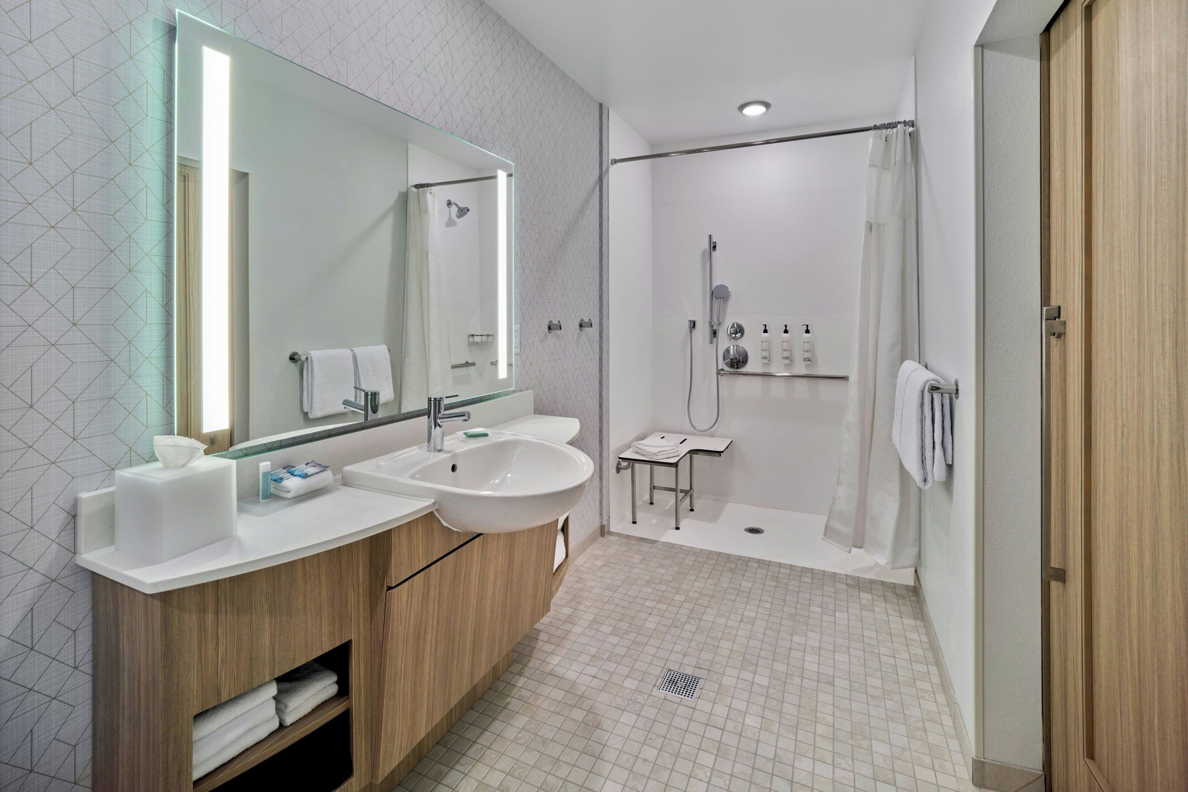 Un baño moderno con dos lavabos, un espejo grande, una ducha y un armario de madera.