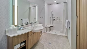Un baño moderno con dos lavabos, un espejo grande, una ducha y un armario de madera.