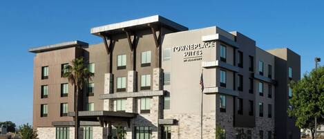 A multi-story hotel with a stone facade, a flat roof, and a sign reading 'TOWNEPLACE SUITES.'