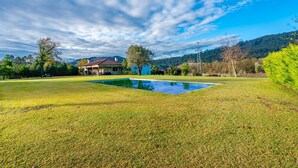 A house with a swimming pool in a grassy yard, surrounded by trees and hills. - Casa Quinta de Agriboa (Ponte de Lima)