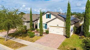 A residential house with a garage, solar panels, and a well-maintained lawn. - Comfort & Tranquility • Saint Cloud•Pool•Lake Nona (St. Cloud)