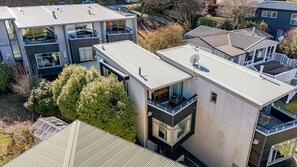 A modern multi-story residential building with balconies, large windows, and satellite dishes. - The Alps Two Bedroom - Spacious escape right in the centre of Queenstown! (Queenstown)