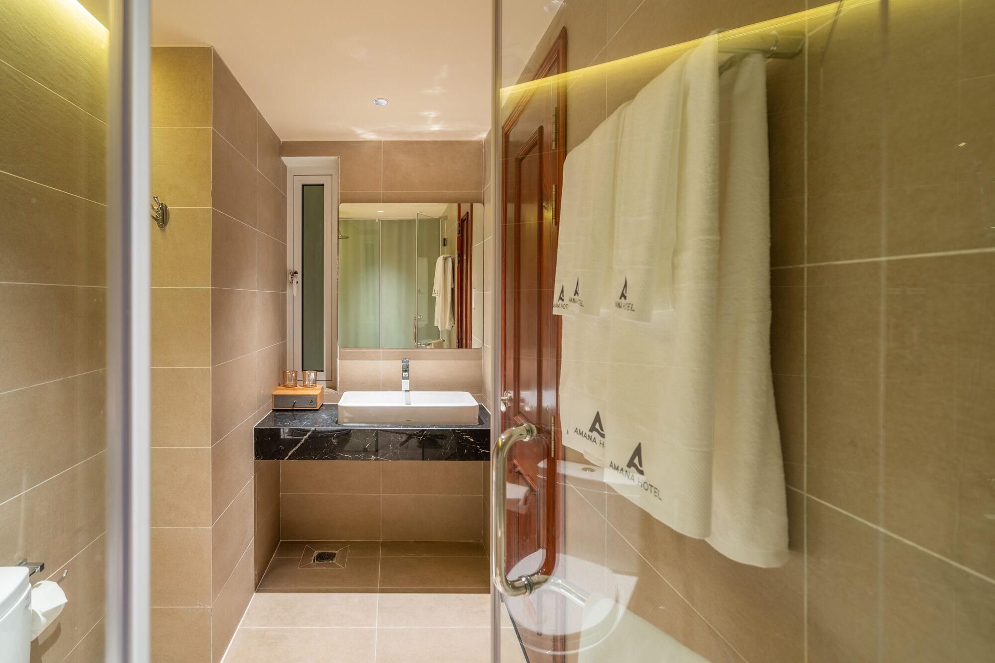 Une salle de bain moderne avec une douche à parois de verre, un lavabo et un miroir.