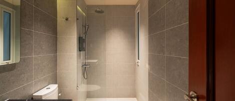 A modern bathroom with a shower, toilet, and sink.