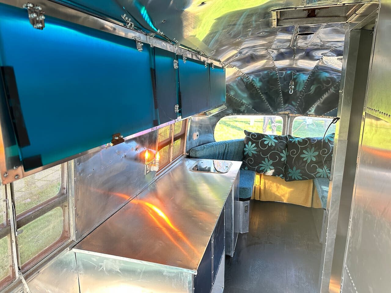A metallic interior with a bench and a window.