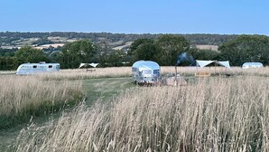 A caravan park with multiple caravans and tents in a grassy field.
