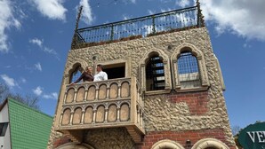 Un edificio con balcón y ventanas de arco.