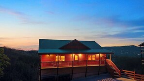 Eine Lodge mit Balkon, Treppe und Blick auf die umliegende Landschaft.