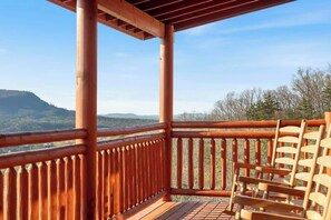 Eine Holzterrasse mit Blick auf eine Berglandschaft.