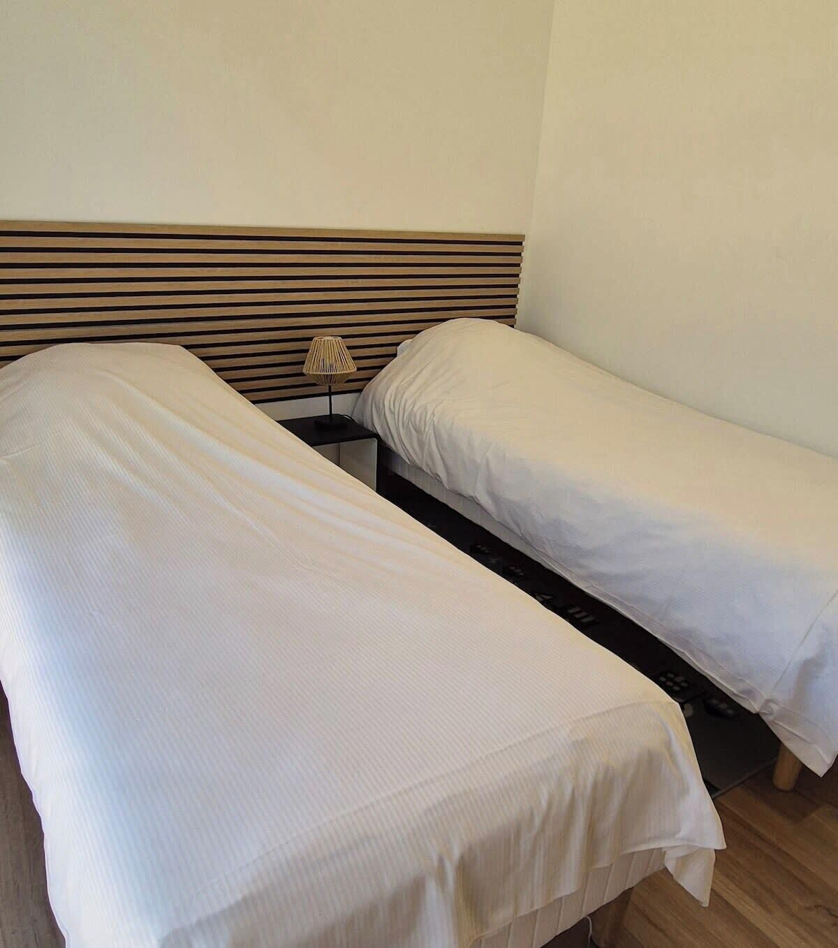 Dos camas individuales con cabeceros de madera en una habitación.