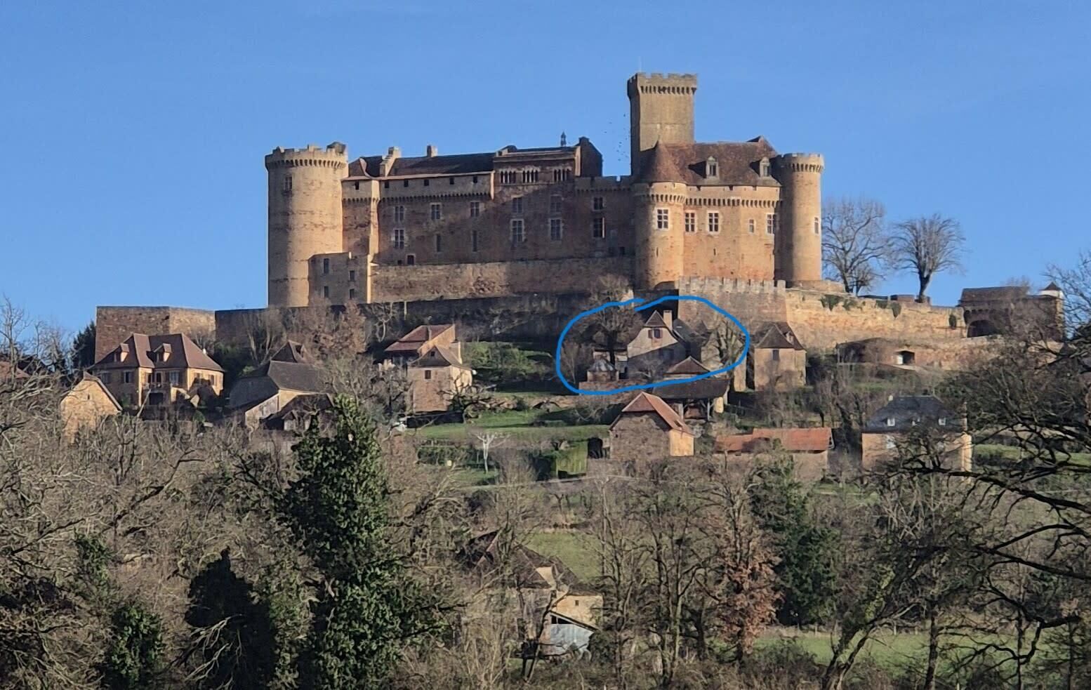 Un château historique doté de nombreuses tours et d’un mur d’enceinte, entouré d’immeubles d’habitation.