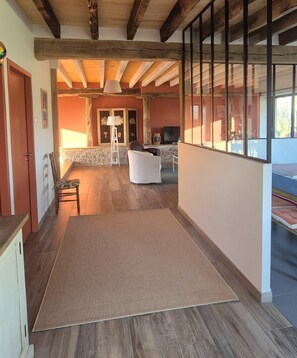 A spacious living area with a wooden ceiling, a large window, and a sofa. - La Bergerie de la Borie, piscine, près Rocamadour (Miers)