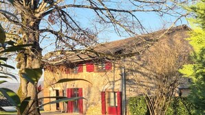 A stone building with red shutters and a small porch. - La Bergerie de la Borie, piscine, près Rocamadour (Miers)