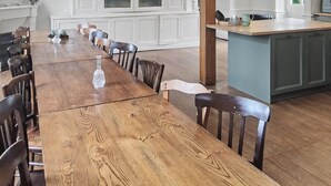 A spacious dining area with a long wooden table and chairs, white cabinetry with glass doors, and a kitchen island. - Maison de la source, swimming pool, 10 min padirac (Alvignac)