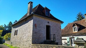 A stone building with a pitched roof, a chimney, and a small window. - The Parrot House (Floirac)