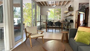 Uma cozinha moderna com área de refeições, grandes janelas e um espaço aconchegante para sentar com sofá e mesa redonda.