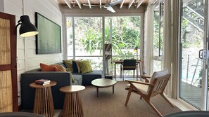 A cozy living area with a sofa, armchairs, a coffee table, and a dining table. - Bungalow in "marAmar" compound, Santa Teresa Beach. Walk everywhere! (Santa Teresa)