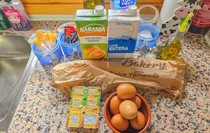 A kitchen counter with various food items, including a carton of milk, a bag of bread, and a bowl of eggs. - Cozy home in Aledo with house a mountain view (Aledo)