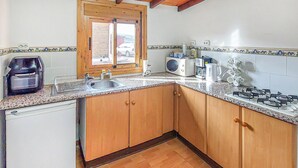 A kitchen with wooden cabinets, a sink, a coffee maker, and a microwave.
