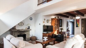 A cozy living room with a fireplace, a television, and comfortable seating. - 3 bedroom nice home in Colonia de Sant Pere (Colonia de Sant Pere)