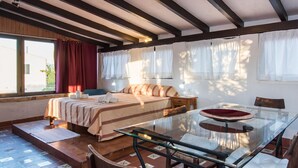 A bedroom with a bed, bedside tables, a glass dining table, and a window with curtains. - 3 bedroom nice home in Colonia de Sant Pere (Colonia de Sant Pere)