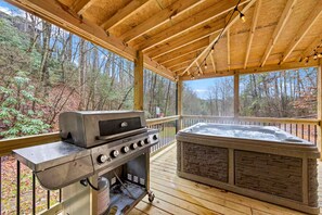 Ein überdachter Außenbereich mit Grill und Whirlpool.