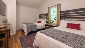 Een slaapkamer met twee bedden, een houten hoofdbord, een nachtkastje met een lamp en een raam met gordijnen.
