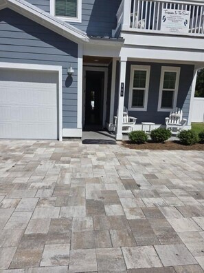 A residential house with a garage, a covered porch, and a paved driveway. - 4-Bedroom Panama City Beach Home with Private Heated Pool (Panama City Beach)