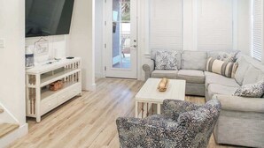 A living room with a sofa, armchairs, a coffee table, a TV, and a white console table. - Panama City Beach 4BR | Private Heated Pool (Panama City Beach)