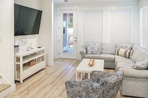 A living room with a sofa, armchairs, a coffee table, a TV, and a white console table. - Panama City Beach 4BR | Private Heated Pool (Panama City Beach)