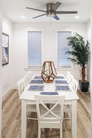 A dining area with a white table, chairs, and a ceiling fan. - 4-Bedroom Panama City Beach Home with Private Heated Pool (Panama City Beach)