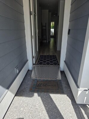 A narrow entrance with a metal step and a welcome mat. - 4-Bedroom Panama City Beach Home with Private Heated Pool (Panama City Beach)