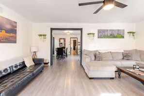 Un salon moderne avec un canapé, une table basse et un ventilateur de plafond.
