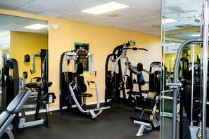 A gym with various exercise machines, mirrors, and a sign indicating a sauna. - 1BR Condo w/ Kitchen + Resort Perks | Near Disney! (Kissimmee)