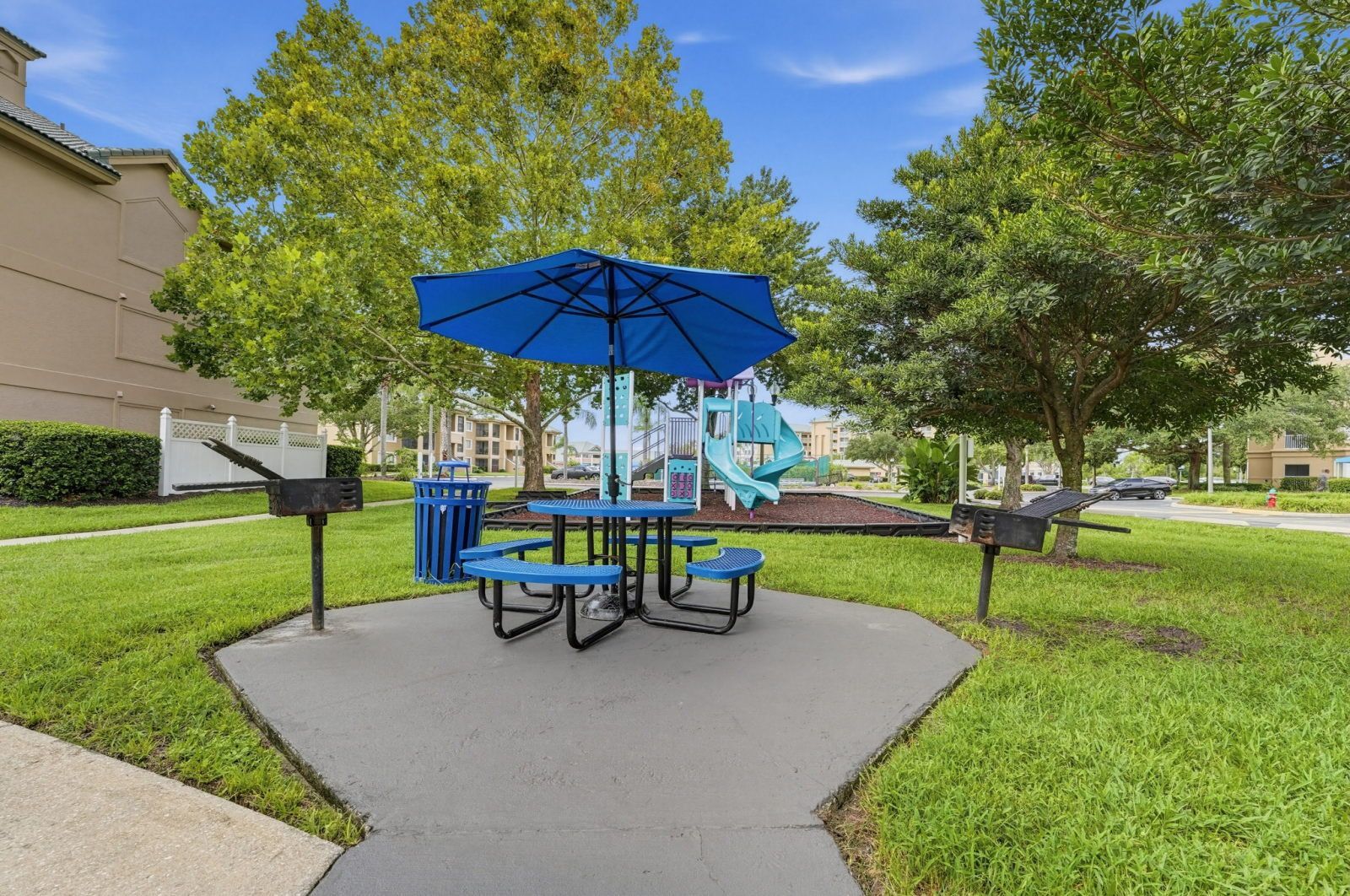Shaded picnic area with a table and blue umbrella for outdoor dining