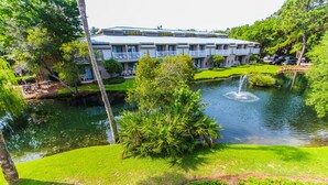 A hotel with a large water feature, lush greenery, and a well-maintained lawn. - 2BR Villa in Hilton Head | Pool Access & More! (Hilton Head Island)