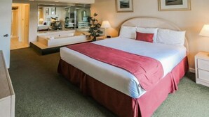 A hotel room with a large bed, a mirror, a bedside table, and a small desk. - 2BR Villa in Hilton Head | Pool Access & More! (Hilton Head Island)