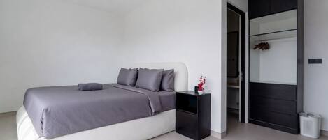 A modern bedroom with a bed, bedside table, and a wardrobe.