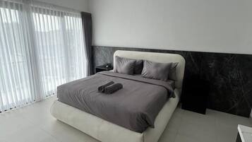 A modern bedroom with a large bed, a nightstand, and a marble accent wall.