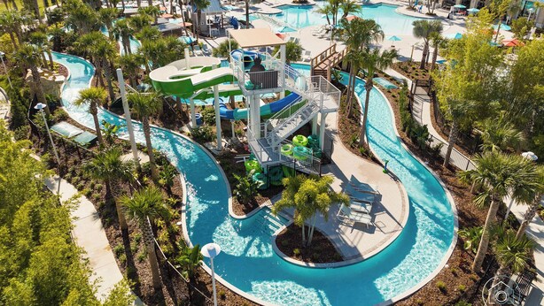 Un parque acuático con múltiples piscinas, toboganes y una piscina de olas.