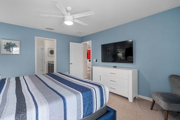 A bedroom with a bed, a white dresser, a television, and a ceiling fan. - Mickey & Minecraft Theme, Pool, Spa Windsor Island (Davenport)