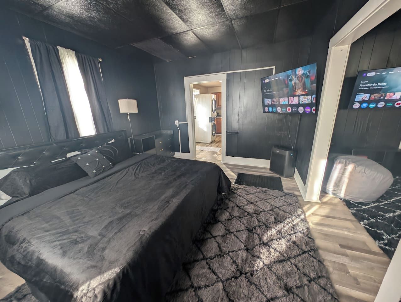 Ein Schlafzimmer mit einem Bett, einem Fernseher und einem Schreibtisch.