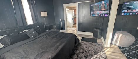 Ein Schlafzimmer mit einem Bett, einem Fernseher und einem Schreibtisch.
