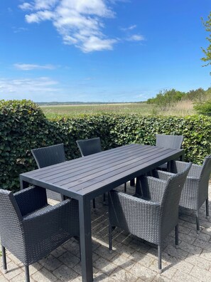 An outdoor patio with a rectangular table and six chairs. - Peaceful holiday home with views of Randers Fjord (Ørsted)